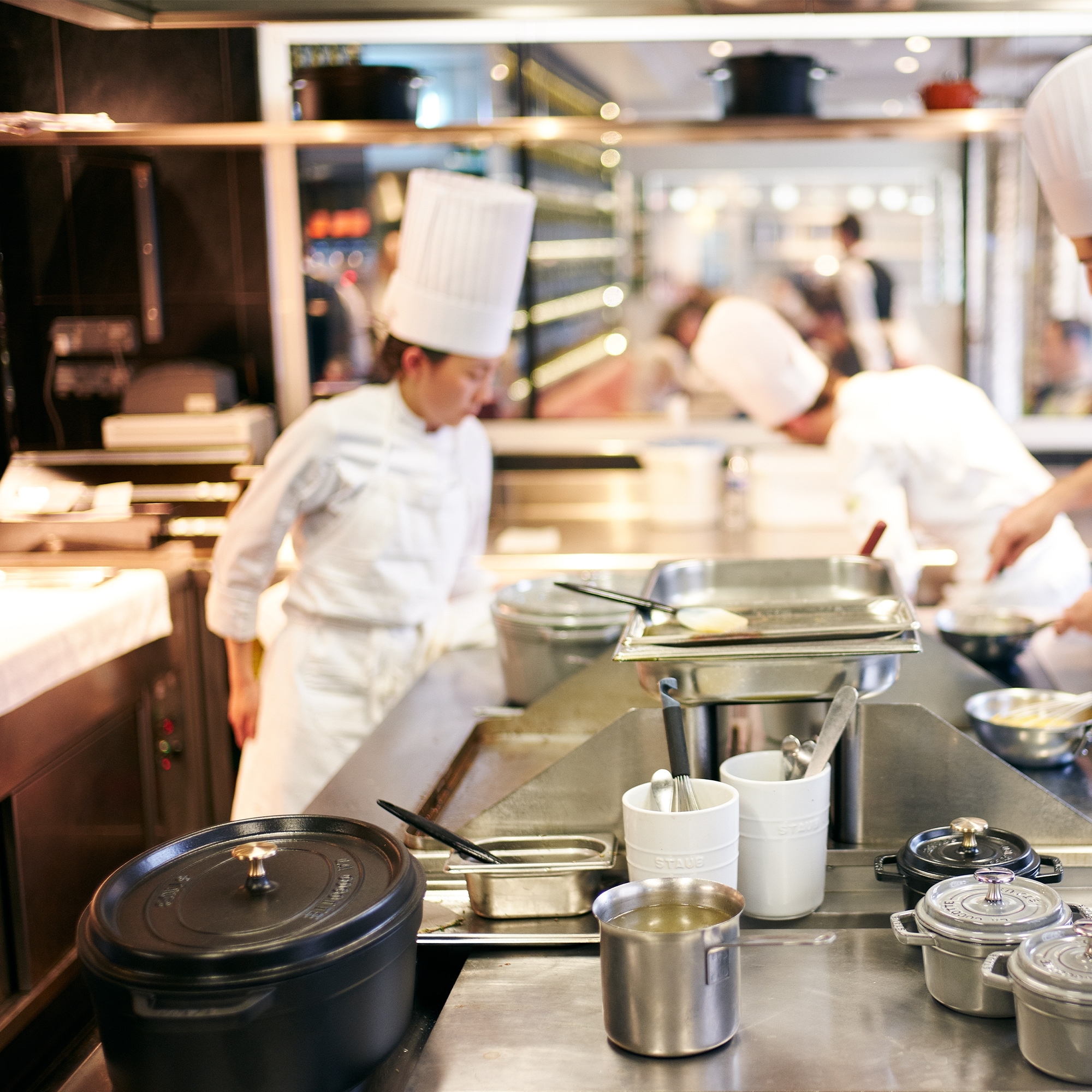 Professional kitchen with chefs and cookware