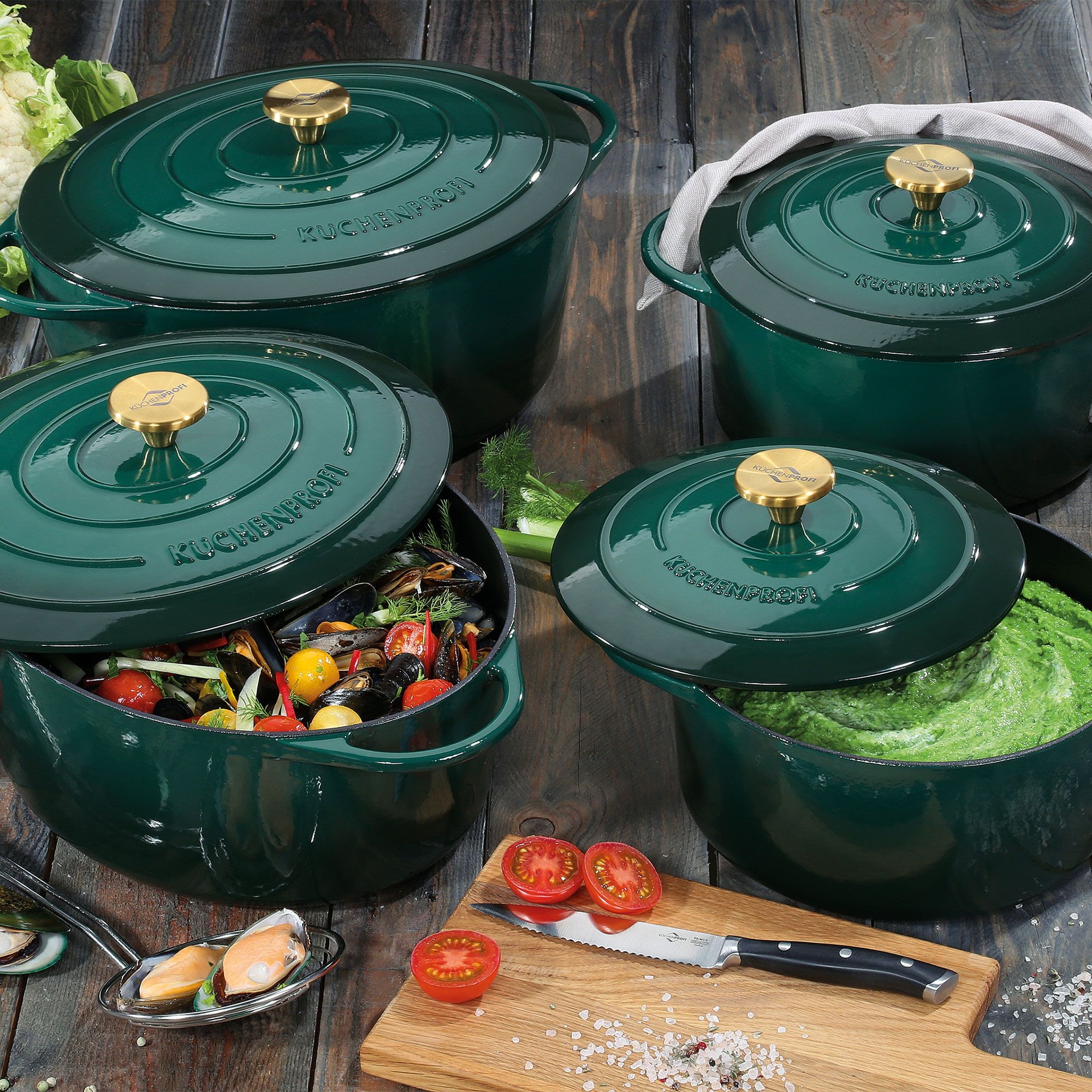 Green cast iron casseroles with food on table