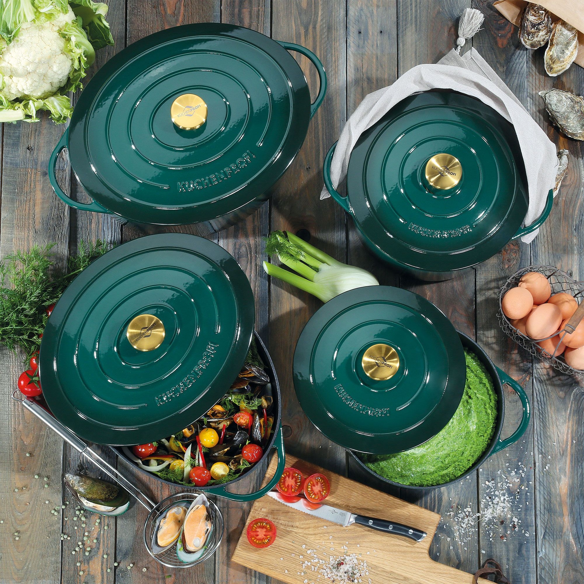 Four green cast iron pots with fresh ingredients