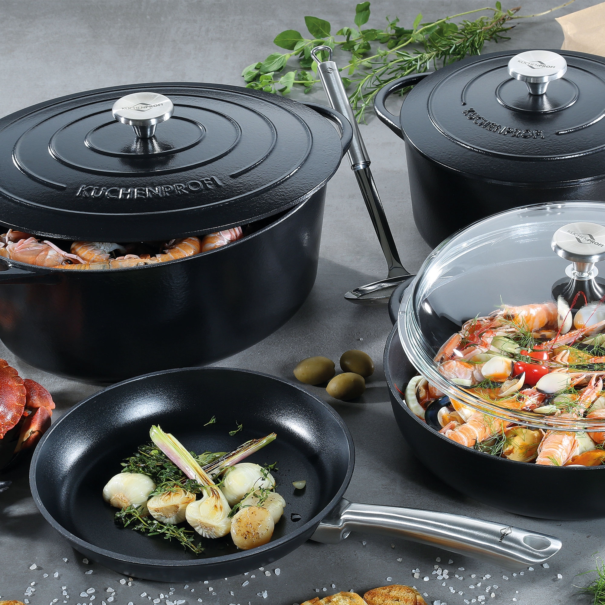 Black cast iron pots and pan with fresh ingredients