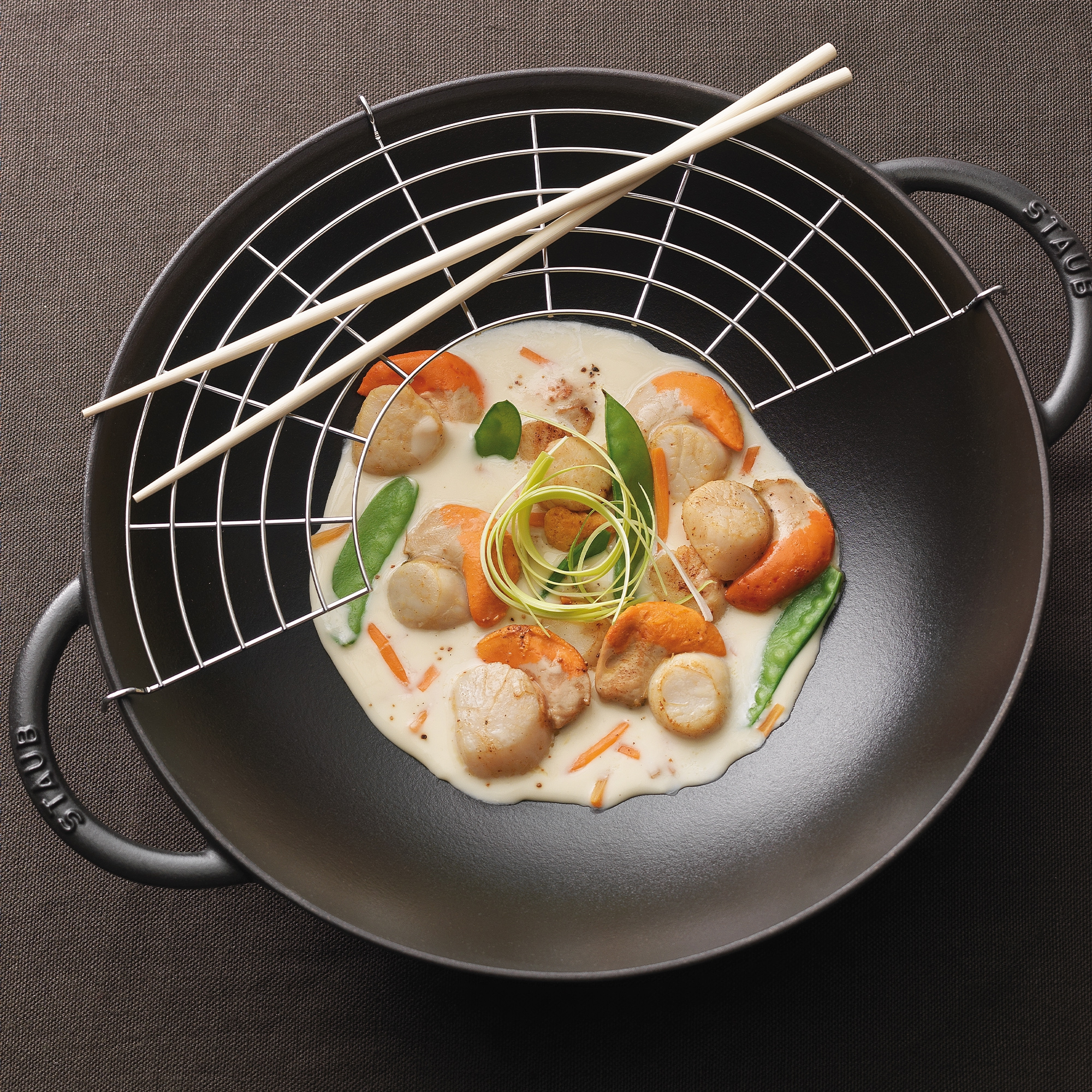 Scallops in creamy sauce with vegetables in Staub wok